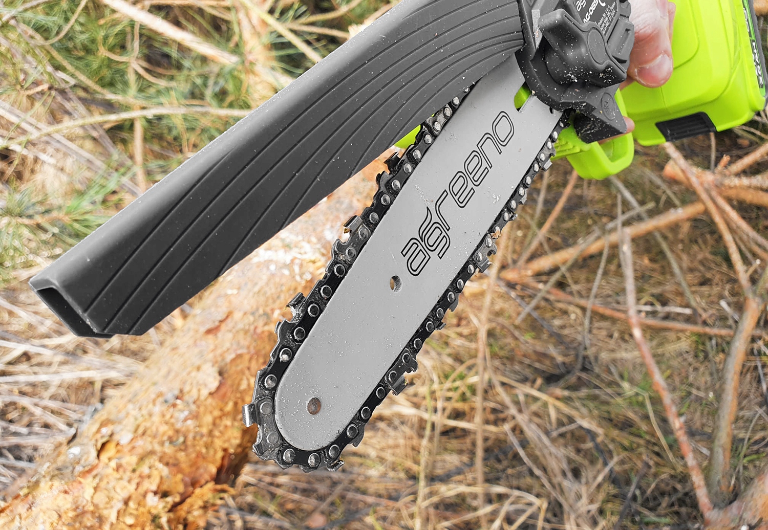 Akumulatorowa pilarka łańcuchowa marki Agreeno  w trakcie cięcia kawałka drewna - ujęcie nr 2